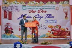 Đại sứ Việt Nam tại Lào Nguyễn Bá Hùng trao quà cho đại diện nhà trường. (Ảnh: Bá Thành/TTXVN)