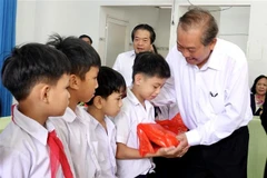 Phó Thủ tướng Thường trực Trương Hòa Bình trao tặng quà cho các trẻ khuyết tật. (Ảnh: Lê Ngọc Phước/TTXVN)