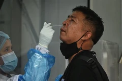 Nhân viên y tế lấy mẫu xét nghiệm COVID-19 cho người dân tại Bangkok, Thái Lan. (Ảnh: AFP/TTXVN)