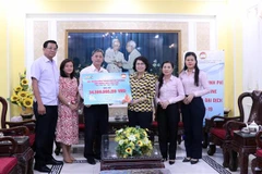 Ông Dương Thanh Tùng, Tổng Giám đốc Đài Truyền hình Thành phố Hồ Chí Minh trao tượng trưng số tiền hơn 34 tỷ đồng quyên góp cho bà Tô Thị Bích Châu, Chủ tịch Ủy ban Mặt trận Tổ quốc Việt Nam Thành phố Hồ Chí Minh. (Ảnh: Xuân Khu/TTXVN)