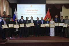 Đại sứ Ngô Đức Mạnh trao bằng khen cho các cá nhân tiêu biểu trong công tác cộng đồng. (Ảnh: Trần Hiếu/TTXVN)