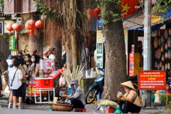 Nhiều hàng rong vẫn tụ tập tại phố Đinh Tiên Hoàng ngay khu vực có biển cấm. (Ảnh: Tuấn Đức/TTXVN)