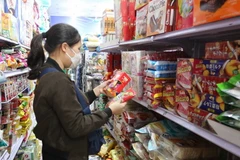 Người dân mua sắm hàng hóa tại siêu thị. (Nguồn: TTXVN)