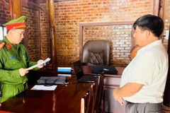 Lực lượng chức năng đọc lệnh khởi tố. (Nguồn: Công an Quảng Bình)