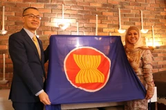 Đại sứ Việt Nam Vũ Quang Minh trao cờ ASEAN và chuyển giao vai trò Chủ tịch luân phiên Ủy ban ASEAN tại Berlin (BAC) cho Đại sứ Brunei Pengiran Krtini Pengiran Tahir. (Ảnh: Thu Hằng/TTXVN)