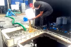 Lực lượng chức năng tiêu hủy số rượu không đảm bảo chất lượng. (Ảnh: TTXVN phát)