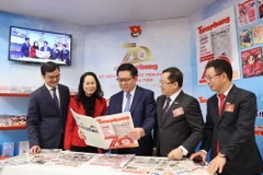 Ông Nguyễn Trọng Nghĩa, Bí thư Trung ương Đảng, Trưởng ban Tuyên giáo Trung ương xem các ấn phẩm của báo Tiền Phong. (Ảnh: Minh Đức/TTXVN)