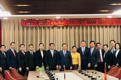 Bí thư Thành ủy Hà Nội Đinh Tiến Dũng chụp ảnh lưu niệm với đoàn đại biểu cấp cao thủ đô Vientiane, Lào. (Ảnh: Tuyết Mai/TTXVN)