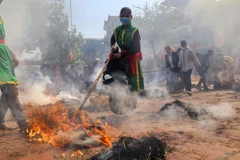 Các nồi cơm được ủ trong đống than rơm để cơm chín đều. (Ảnh: Tuấn Đức/TTXVN)