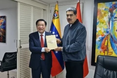 Ông Phan Đình Trạc tặng Tổng thống Venezuela Nicolas Maduro cuốn sách "Một số vấn đề lý luận và thực tiễn về chủ nghĩa xã hội và con đường đi lên chủ nghĩa xã hội ở Việt Nam" của Tổng Bí thư Nguyễn Phú Trọng. (Ảnh: Mai PhươngTTXVN)
