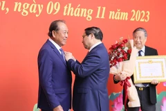 Thủ tướng Phạm Minh Chính trao tặng Huy hiệu 50 năm tuổi Đảng cho ông Trương Hòa Bình, nguyên Ủy viên Bộ Chính trị, nguyên Phó Thủ tướng Thường trực Chính phủ. (Ảnh: Dương Giang/TTXVN)