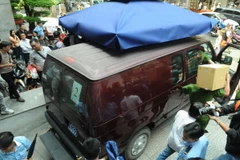 Xe của Cơ quan Cảnh sát điều tra Bộ Công đưa hai nhân viên Eximbank Chi nhánh Thành phố Hồ Chí Minh rời khỏi trụ sở Eximbank Chi nhánh Thành phố Hồ Chí Minh (trưa 26/3). (Ảnh: Thành Chung/TTXVN)