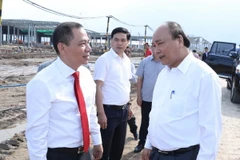 Thủ tướng Nguyễn Xuân Phúc trao đổi với ông Phạm Nhật Vượng, Chủ tịch Hội đồng quản trị Tập đoàn Vingroup tại khu vực hạng mục đang được xây dựng của Nhà máy ôtô Vinfast. (Ảnh: Thống Nhất/TTXVN)