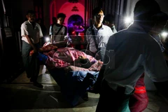 Bệnh nhân được sơ tán bằng cáng khỏi hiện trường vụ hỏa hoạn. (Nguồn: EPA)