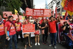 Người dân tham gia tuần hành yêu cầu Chính phủ sửa đổi chính sách lao động tại Manila, Philippines ngày 1/5. (Nguồn: AFP/TTXVN)