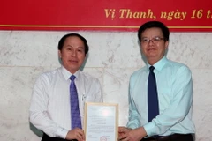 Ông Mai Văn Chính, Phó Trưởng ban Tổ chức Trung ương trao quyết định cho ông Lê Tiến Châu. (Ảnh: Duy Khương/TTXVN)