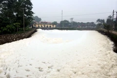 Trạm bơm Chợ Lương hoạt động, nước sủi bọt kết thành tảng lớn, bốc mùi hôi thối. (Ảnh: Thanh Tuấn/TTXVN)