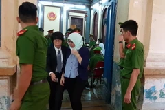 Bị cáo Bùi Thị Kim Loan (quấn khăn) được yêu cầu tham gia phiên xử ngày 15/5 để Hội đồng xét xử xét hỏi. (Ảnh: Thành Chung/TTXVN)