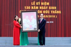 Chủ tịch nước Trần Đại Quang tặng bức tranh Bác Hồ với Bác Tôn cho Đảng bộ, chính quyền và nhân dân các dân tộc tỉnh An Giang. (Ảnh: Nhan Sáng/TTXVN)