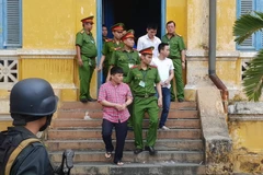 Bị cáo Nguyễn Đức Sinh (áo kẻ), người chủ mưu và ném bom xăng đốt kho tạm giữ xe vi phạm của Công an thành phố Biên Hòa. (Ảnh: Thành Chung/TTXVN)