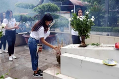 Thanh niên, sinh viên kiều bào tiêu biểu thắp hương tại khu mộ 10 liệt sỹ thanh niên xung phong tại Khu di tích Ngã ba Đồng Lộc. (Ảnh: Công Tường/TTXVN)