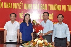 Bà Lê Thị Ái Nam, Phó Bí thư Thường trực Tỉnh ủy, Chủ tịch Hội đồng Nhân dân tỉnh, tặng hoa chúc mừng ông Lê Thanh Hùng. (Ảnh: Huỳnh Sử/TTXVN)
