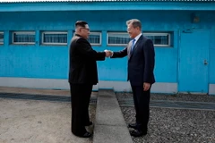 Tổng thống Hàn Quốc Moon Jae-in (phải) và nhà lãnh đạo Triều Tiên Kim Jong-un bắt tay hữu nghị tại đường phân định ranh giới hai miền ở làng đình chiến Panmunjom ngày 27/4. (Nguồn: Yonhap/TTXVN)