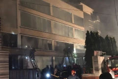 Lực lượng chữa cháy nỗ lực khống chế đám cháy. (Ảnh: Thành Chung/TTXVN)