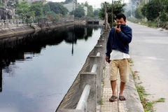 Người dân đi qua khu vực sông Đoan Túc cũng không thể chịu được mùi hôi thối của dòng sông. (Ảnh: Thế Duyệt/TTXVN)