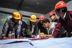 Lực lượng cứu hộ bàn cách thức giải cứu các thợ mỏ bị mắc kẹt sau vụ nổ tại mỏ quặng sắt Bàn Khê ngày 5/6. (Nguồn: THX/TTXVN)