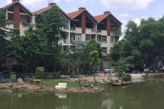 Một phần hồ bị người dân đổ đất đá, vật liệu san lấp lấn chiếm. (Ảnh: Nguyễn Văn Cảnh/TTXVN)