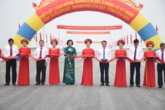 Các đại biểu thực hiện nghi thức cắt băng thông xe. (Ảnh: Việt Dũng/TTXVN)