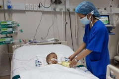 Bệnh Nhi Đặng Bảo A. sau khi phẫu thuật được hồi sức tại Bệnh viện đa khoa Đồng Nai. (Ảnh: Lê Xuân/TTXVN)