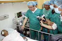 Bí thư Thành ủy Nguyễn Thiện Nhân thăm anh Trần Văn Hoàng, Đội trưởng Đội "hiệp sỹ đường phố" quận Tân Bình, đang điều trị tại Bệnh viện 115. (Ảnh: Hoàng Hải/TTXVN)