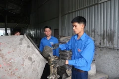 Anh Lương Viết Toàn tại cơ sở sản xuất hàng rào bêtông ly tâm. (Ảnh: Hiền Anh/TTXVN)