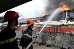 Lực lượng phòng cháy chữa cháy tích cực dập lửa tại khu vực cháy. (Ảnh: Trung Kiên/TTXVN)