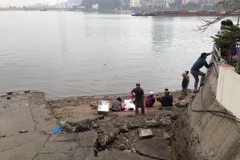 Thi thể nạn nhân được đưa vào bến phà cũ. (Ảnh: Trung Nguyên/Vietnam+)