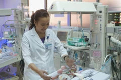 Bác sỹ Phạm Thị Thanh Tâm, Trưởng khoa Hồi sức Sơ sinh Bệnh viện Nhi đồng 1, Thành phố Hồ Chí Minh thăm khám bệnh nhi sau phẫu thuật. (Ảnh: Phương Vy/TTXVN)