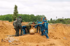 Lực lượng chức năng di dời quả bom. (Ảnh: TTXVN phát)