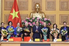 Thủ tướng Nguyễn Xuân Phúc tặng quà cho các đại biểu tại buổi gặp mặt. (Ảnh: Thống Nhất/TTXVN)