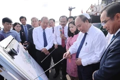 Thủ tướng Nguyễn Xuân Phúc và Phó Thủ tướng Thường trực Trương Hòa Bình xem sơ đồ Cảng Quốc tế Long An. (Ảnh: Thống Nhất/TTXVN)