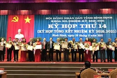 Tặng Bằng khen cho các cá nhân có nhiều đóng góp trong hoạt động của Hội đồng nhân dân tỉnh Bình Định khóa XII. (Ảnh: Phạm Kha/TTXVN)