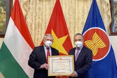 Đại sứ Nguyễn Tiến Thức trao Bằng khen của Bộ trưởng Ngoại giao cho Hội Hữu nghị Hungary-Việt Nam. (Ảnh: Đại sứ quán Việt Nam tại Hungary)