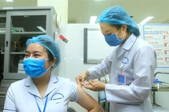 Điều dưỡng viên khu cách ly Bệnh viện Việt Tiệp cơ sở 2 Bùi Thị Thanh Nhung, sinh năm 1987, được tiêm mũi liều vaccine ngừa COVID-19 đầu tiên tại Hải Phòng. (Ảnh: An Đăng/TTXVN)