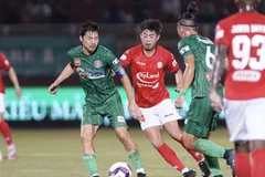 Pha tranh bóng giữa các cầu thủ đội Thành phố Hồ Chí Minh (áo đỏ) và đội Sài Gòn FC. (Ảnh: Thanh Vũ/TTXVN)