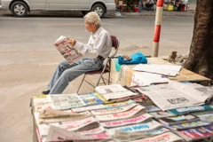 Trải qua hai năm đại dịch COVID-19, báo giấy dù vẫn phát hành nhưng không còn thu hút độc giả như trước. Hình ảnh người dân cầm tờ báo để đọc cũng ngày càng ít đi. (Ảnh: Minh Sơn/Vietnam+)
