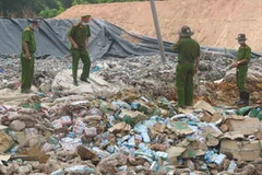 Cảnh sát môi trường điều tra tại hiện trường chôn sữa. (Nguồn: Vietnamnet)