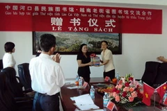 Phó Giám đốc Sở VH-TT-DL tỉnh Lào Cai trao tặng sách cho Thư viện Hà Khẩu, Vân Nam, Trung Quốc. (Nguồn: laocai.gov.vn)