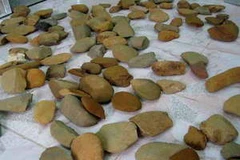 Các di vật công cụ lao động bằng đá khai quật được từ di chỉ Sủa Cán Tỷ. (Ảnh: Minh Tâm/TTXVN)