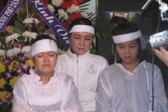 Đối tượng Trần Thúy Liễu cùng hai con trong lễ tang nhà báo Hoàng Hùng. (Nguồn: Internet)